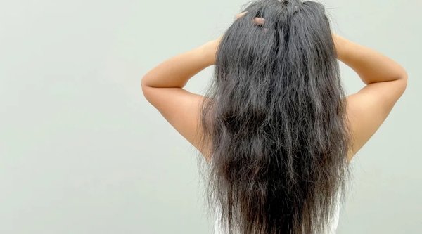 tampak belakang seorang wanita dengan rambut kusam