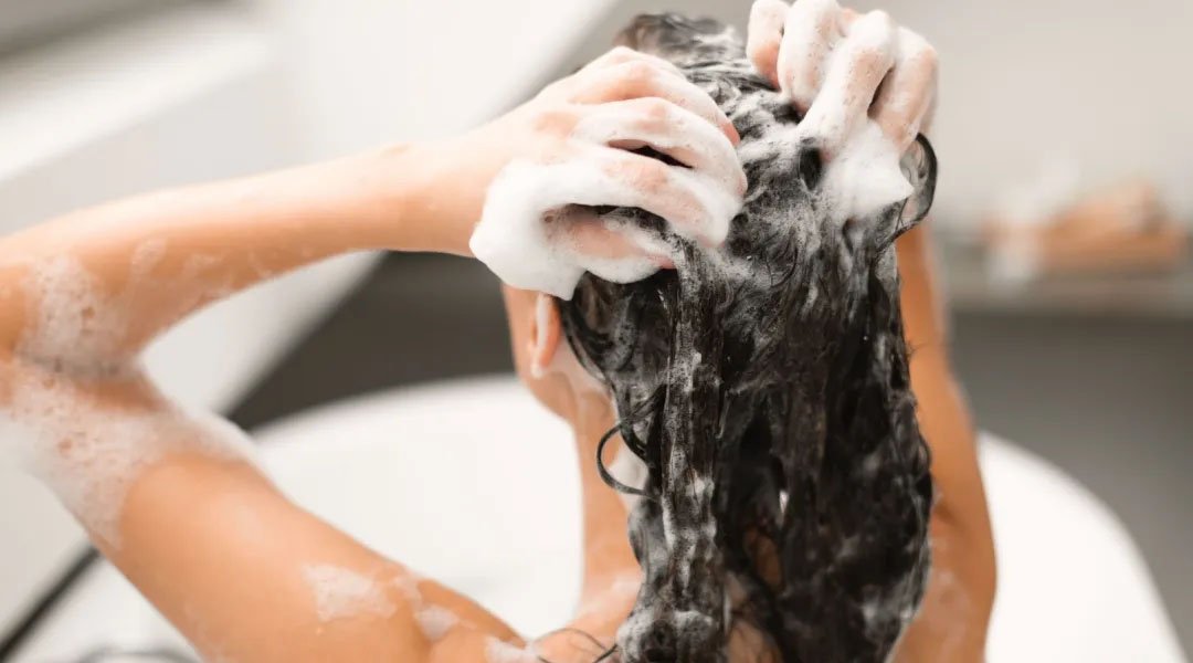 wanita menggunakan shampoo untuk rambut rontok terbaik dari Kérastase