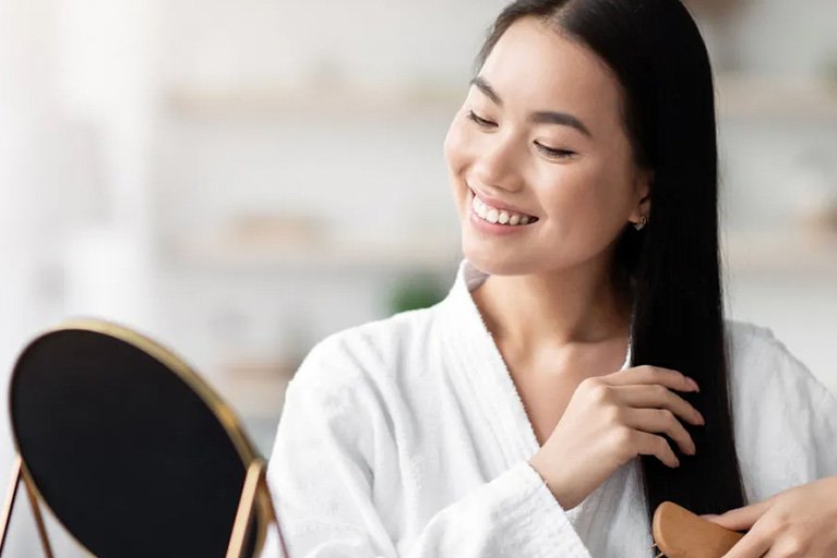 wanita sedang menyisir mencoba cara mengatasi rambut kering